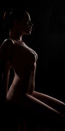 Model bare breasted sitting by Alex Neumayer