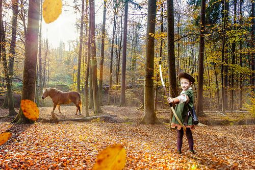 Jongen speelt Robin Hood in herfstbos