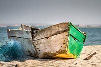 Old wooden fishing boat on the beach with fishing net