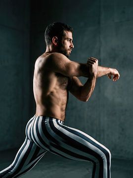 Mann dehnt sich und bereitet sich auf ein Fitnesstraining vor von Markus Gann