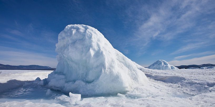 Block of ice in the form of a hill or mountain on Lake Baikal, blue ice hummock under the blue sky by Michael Semenov