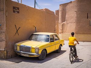 Gele auto in de straten van Yazd, Iran van Teun Janssen