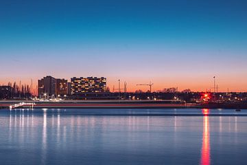 Long exposure of waterboat on the Scheldt during sunset with skyline of Linkeroever Antwerp by Daan Duvillier | Dsquared Photography