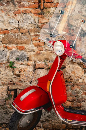 Rode (vintage) vespa scooter in Siena Italië.