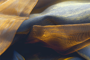 Gold und Blau im Fluss – Lichtspiel auf transparentem Stoff