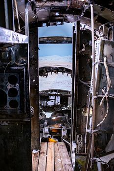 Interieur van DC-3 vliegtuigwrak met doorkijk naar besneeuwd landschap, Eyvindarholt, IJsland