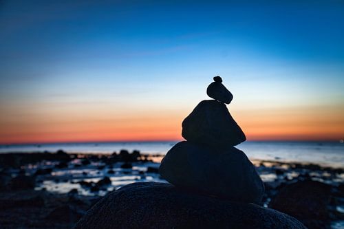 Stone pyramid on the Baltic Sea with a view of the sea at sunset and blue hour