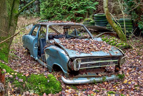 Voiture abandonnée dans une forêt en automne