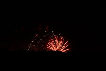 Roter Glitzer und Streifen von explodierenden Feuerwerkskörpern auf einer tollen Party von adventure-photos