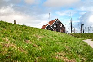 Hoher Seedeich mit traditionellem Fischerhäuschen am Hafen
