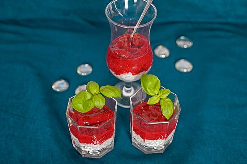 Dessert met frambozenpuree geserveerd in een glas