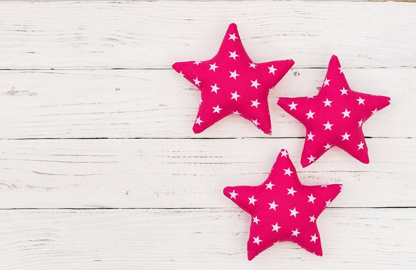 Decoration with three pink stars on white wood with copy space by Alex Winter