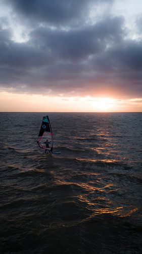 Windsurfer au coucher du soleil en pleine mer