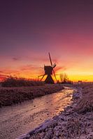 Een van de molens uit kinderdijk voor zonsopkomst met hoge bewolking