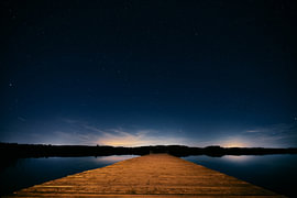 Wooden walkway at Bannwaldsee beneath the starry sky