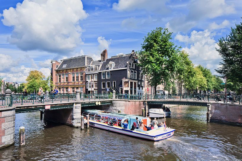 Amsterdam canal belt with a view on bridges and a tour boat  by Tony Vingerhoets