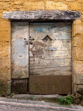 Rustieke verweerde houten deur in kalksteen huis van Wil Wijnen