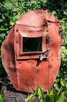 Rust and Ruin – Forgotten Welding Mask Overtaken by Nature