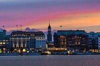 Zicht op de St Michael kerk in Hamburg tussen de huizen aan de Inner Alster tijdens het blauwe uur