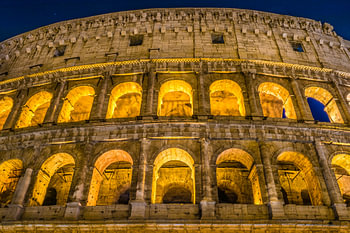 The Great Roman Colosseum and its arches at night in Rome - Italy