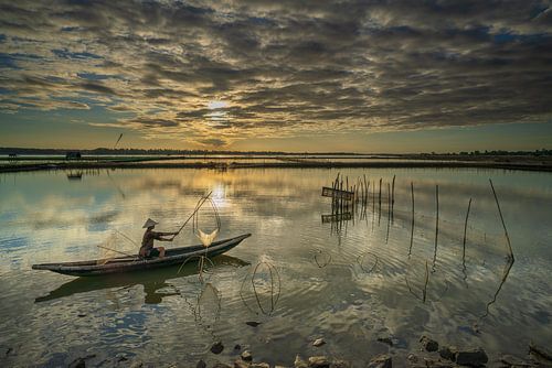 Een visser in Vietnam met een traditioneel visnet