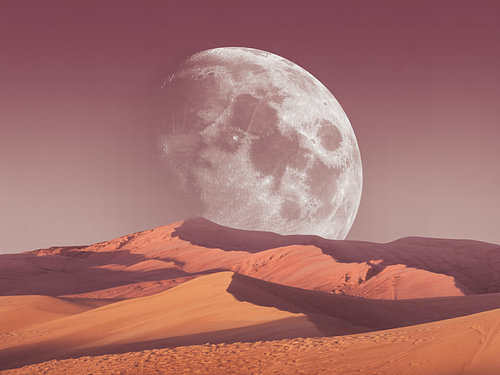 Reusachtige volle maan boven dromerige woestijnduinen in stoffige mauve- en warme zonsondergangtinten