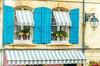 Provence style windows with azure blue shutters.