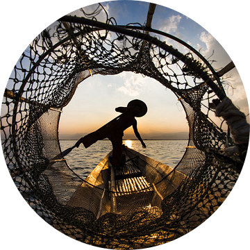 Visser die met traditionele boot op het Inle meer in Myanmar op ouderwetse wijze met een vis korf vi van Wout Kok