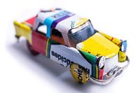 Fröhliches gelbes Oldtimer-Auto Nahaufnahme eines handgefertigten Blechspielzeugautos in Miniaturfor
