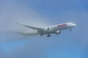Die SWISS Boeing 777-300 taucht aus dem Nebel auf.