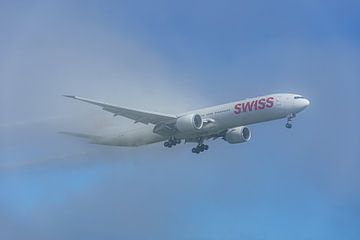 SWISS Boeing 777-300 komt uit de mist tevoorschijn.