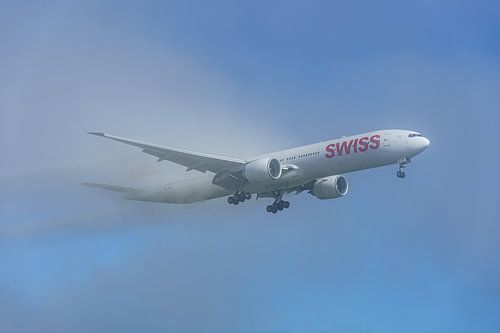 SWISS Boeing 777-300 komt uit de mist tevoorschijn.