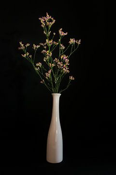 Nature morte avec des fleurs colorées dans un vase blanc