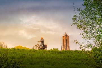 fietster voor de Eusebiuskerk in Arnhem tijdens de zonsongergang van Bart Ros