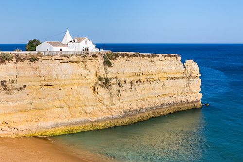 Witte kerk op rots aan zee van Portugal