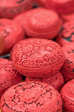 Chinese engraved egg-shaped red boxes on a market by Tony Vingerhoets