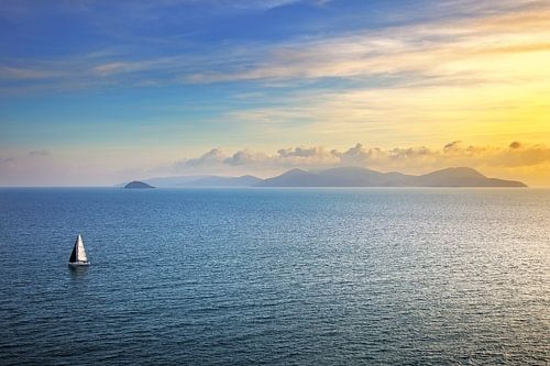 Zonsondergang op het eiland Elba vanaf Piombino en een zeilboot