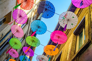 Bunte Regenschirme, die als farbenfrohe Dekoration über einer Straße hängen