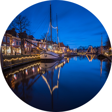 Dokkum met verlichte boten in het water
