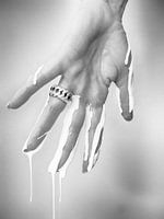 Vrouwenhand met druppelende muurverf (Monotoon)