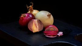 Onions on a wooden cutting board by R Smallenbroek