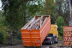 Lkw auf einer Baustelle, der einen Container aufnimmt