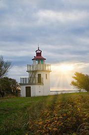 Lighthouse by the sea and rays of sunshine by Martin Köbsch