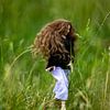 Jonge  vrouw met lang bruin haar in het hoge gras. van Margreet van Tricht