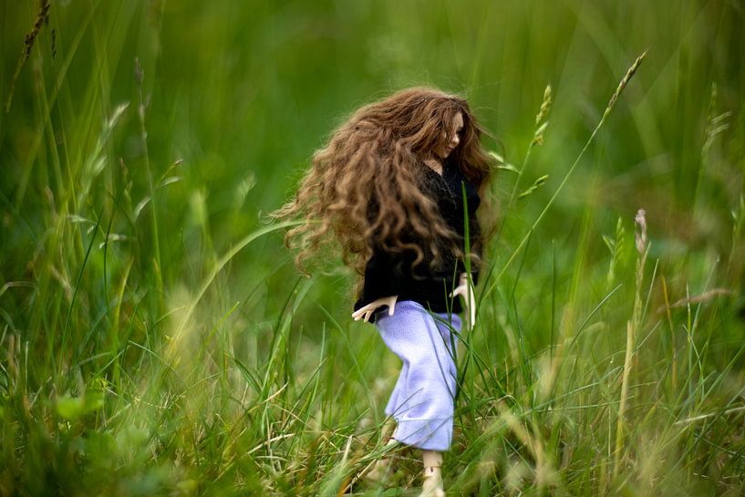 Jeune femme aux longs cheveux bruns dans les hautes herbes. par Margreet van Tricht