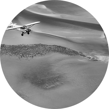Vliegtuig boven de Waddenzee in zwart-wit van Planeblogger