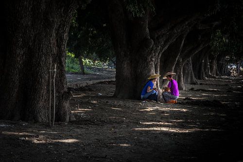 Two women from Myanmar seek shade under the trees. Wout Kok One2expose Photography by Wout Kok