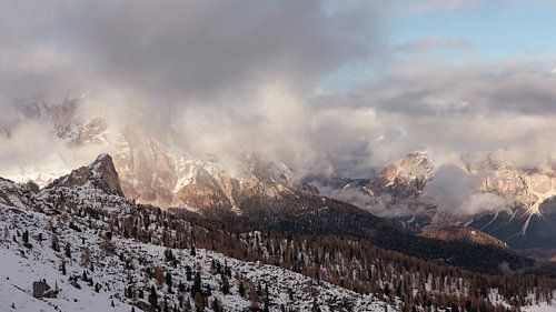 Met sneeuw bedekte bergen gevangen in een zee van wolken