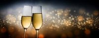 Happy New Year 2020, two champagne glass flutes toasting against a dark background with blurry bokeh by Maren Winter thumbnail