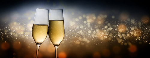 Frohes Neues Jahr 2020, zwei Champagnerglasflöten toasten vor dunklem Hintergrund mit verschwommenem